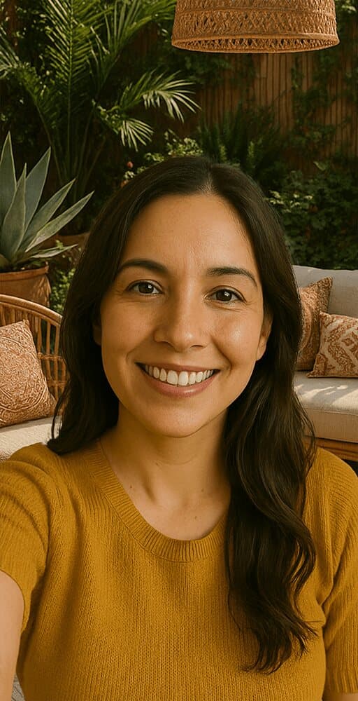 A seller's selfie: a smiling woman with long dark hair, in a living room full of plants.
